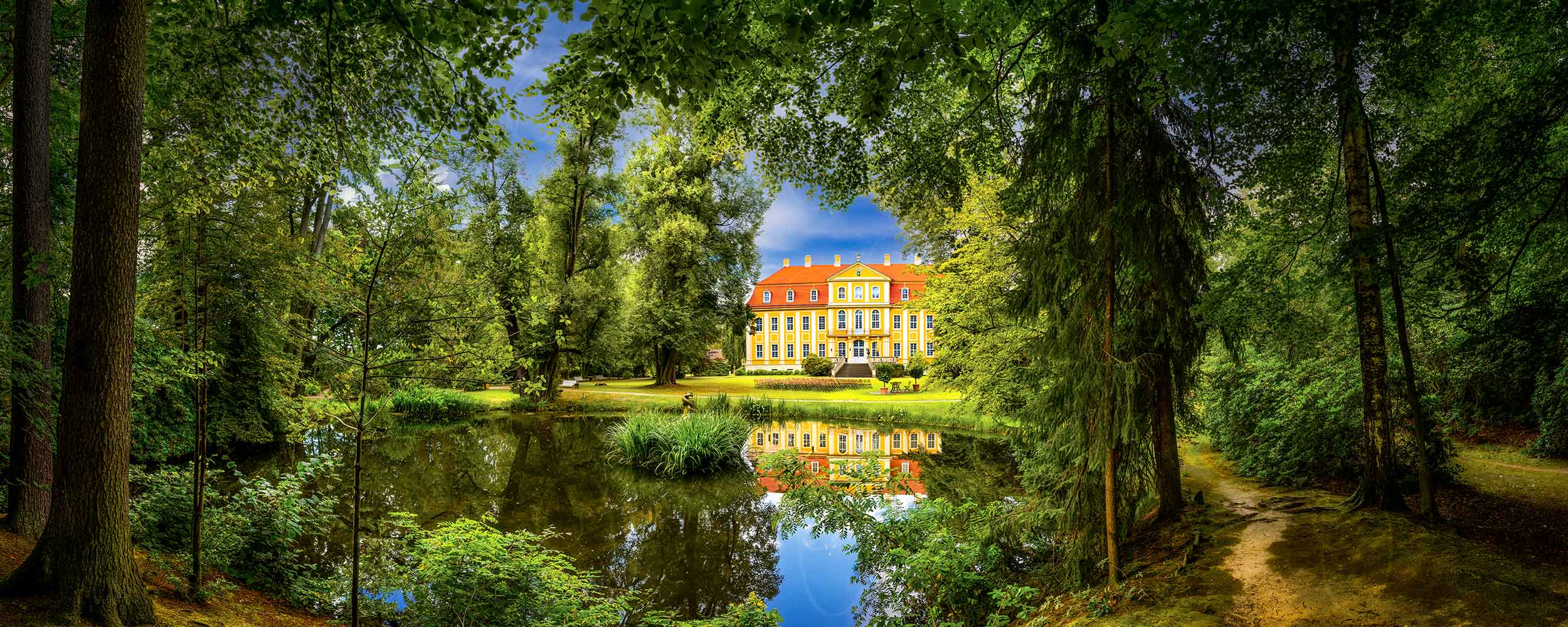Rammenau – Majestätisch umrahmen Parkbäume das leuchtende Barockschloss